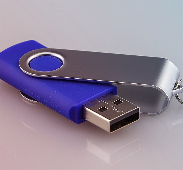 Ein blauer USB-Stick auf grauem Grund.