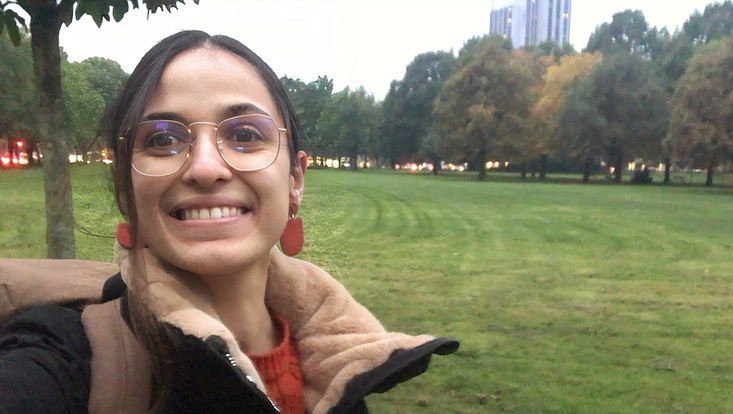 woman with glasses and red earrings in front of a lawn