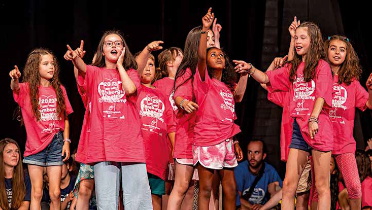 Kinder des TheaterSprachCamp stehen auf einer Bühne.