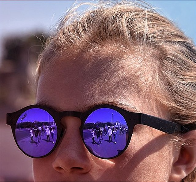 Kind mit blau spiegelnder Sonnenbrille