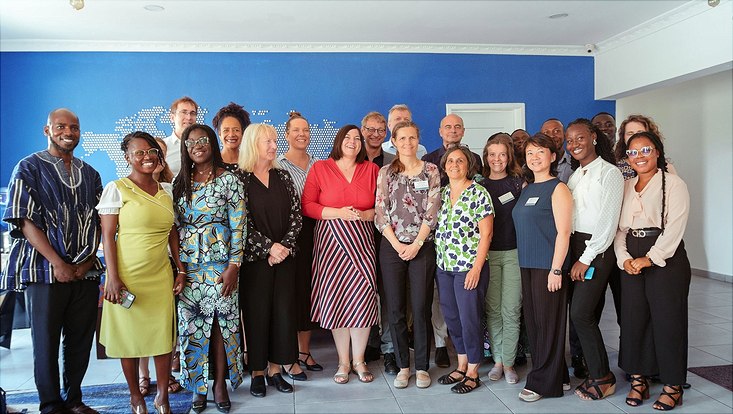 The picture shows a group of approximately 20 people from the delagtion smiling for the camera