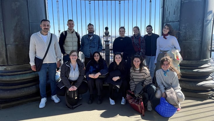 Gruppenfoto mit lächelnden Gaststudierenden auf der Aussichtsplattform des Michels