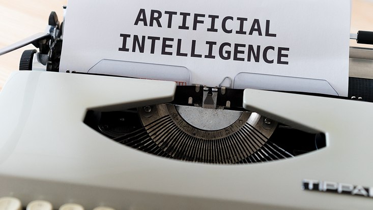 Type Writer with a sheet of paper that says "Artificial Intelligence"