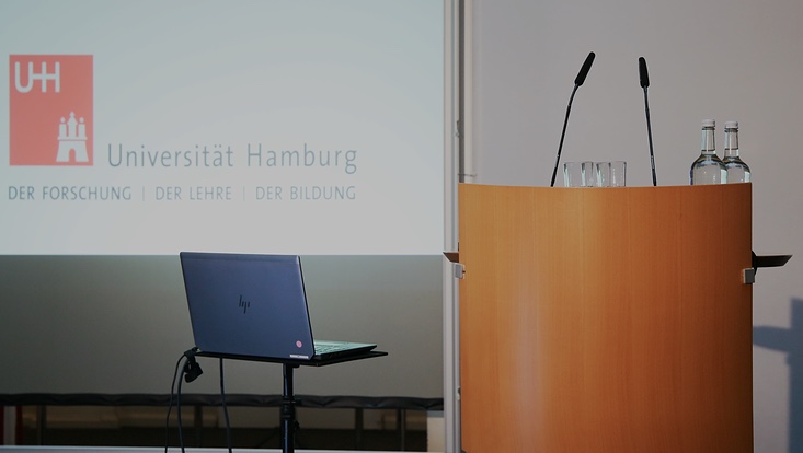 2-733x414 Bild von leerem Sprecherpult. Präsentation im Hintergrund.