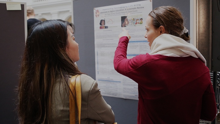 10-733x414 Zwei Frauen, die über ein Poster sprechen