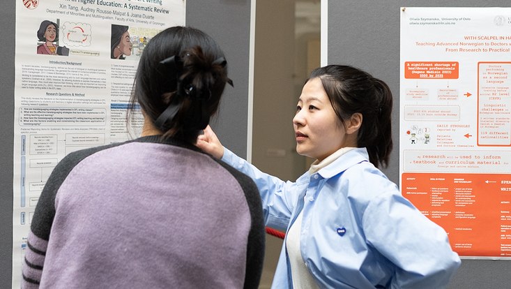21-733x414 Eine Frau zeigt einer anderen Frau ein Poster.