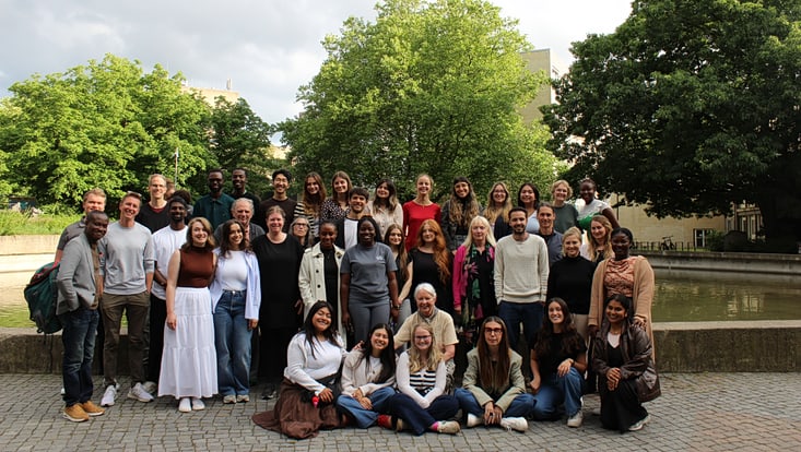 Das Foto zeigt die Teilnehmenden des Study Camps sowie die Betreuenden in einer Gruppe vorm Springbrunnen auf dem Campus der UHH