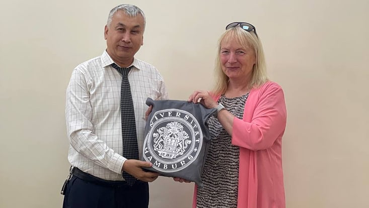 Telse Iwers überreicht dem Partner der Weltsprachenuniversität einen UHH-Beutel als Gastgeschenk