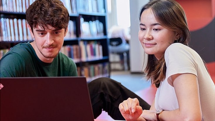 Studierende am Laptop im Gespräch