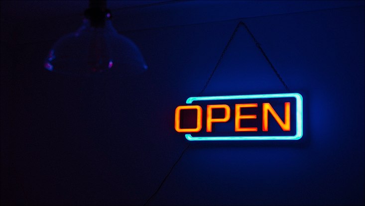Dunkles Bild mit neonhellem Schild "open"