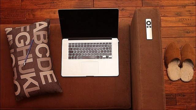 Ein Sofa mit Kissen und Notebook von oben fotografiert.