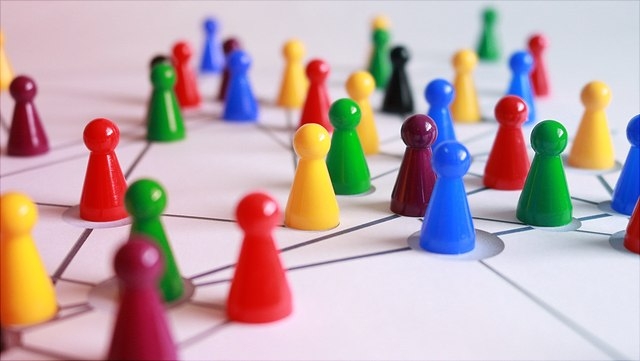 Spielfigürchen auf einem weißen Spielbrett mit schwarzen Verbindungslinien
