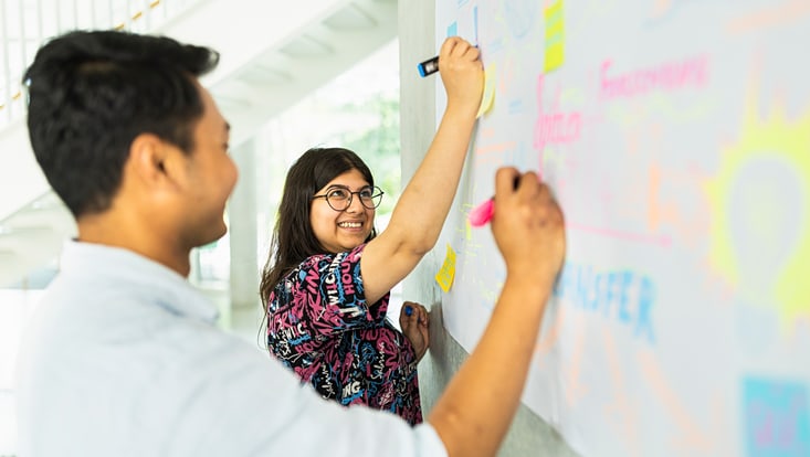 Zwei Personen an einem Whiteboard