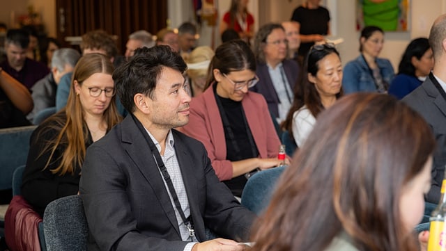Menschen auf Stühlen, während einer Netzwerkkonferenz