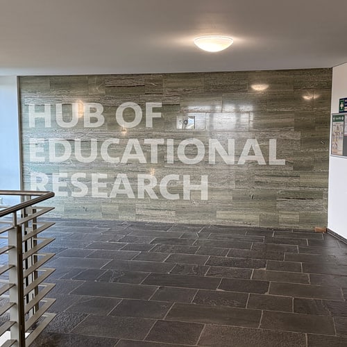Der Schriftzug Hub of Educational Research an der Flurwand zum 5. OG