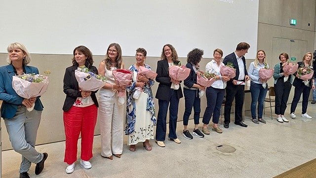 Gruppenbild auf Podium mit Blumen