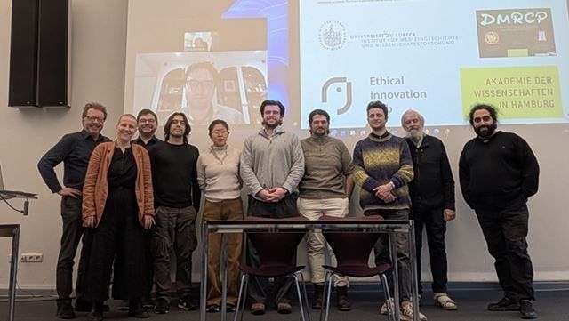 Gruppenbild der WorkshopteilnehmnerInnen auf Bühne vor Screen