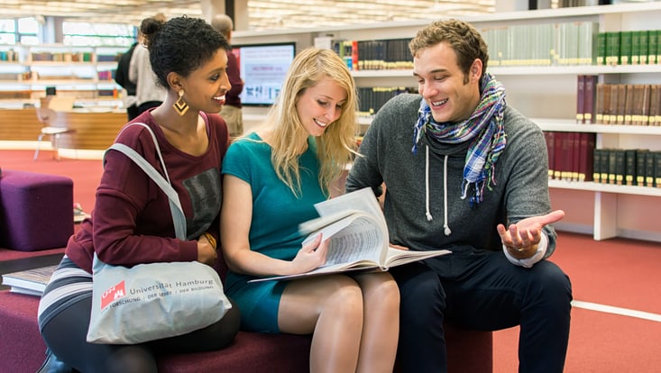 Drei Studierende in der Stabi Drei Studierende unterhalten sich in der Bibliothek