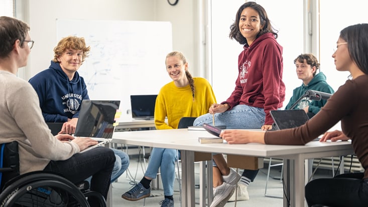Sechs Studierende sitzen um einen Tisch Sechs Studierende sitzen um einen Tisch und unterhalten sich
