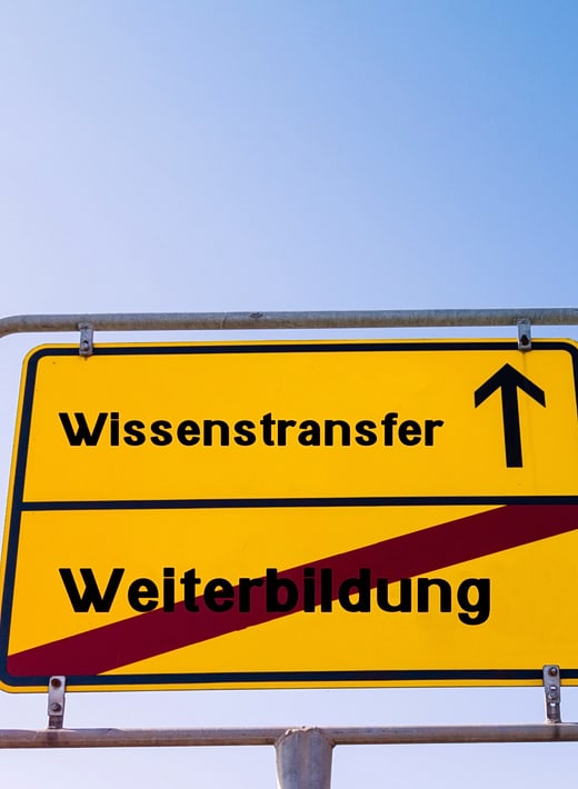 Transfer Ortsschild mit der Aussage: Sie verlassen Weiterbildung, nächster Ort ist Wissenstransfer.
