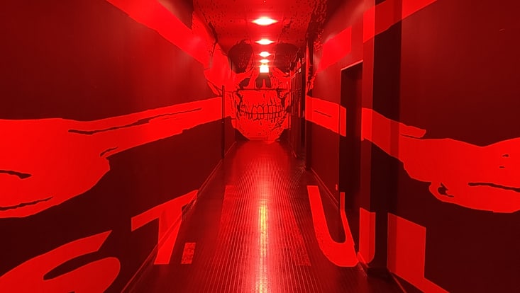 Ein rot beleuchtetet Gang auf dem ein weißer Totenkopt und er Schriftzug St. Pauli aufgezeichnet sind. Der Gang wurde im St.Pauli Stadion fotografiert.