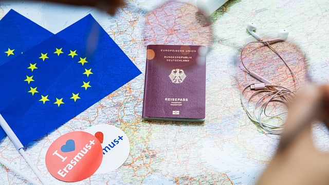 Schreibtisch mit Reisepass, Landkarte und Erasmus-Sticker