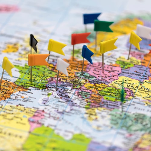 bunte Europakarte mit Fähnchen-Pins an den Orten unserer Partnerunis