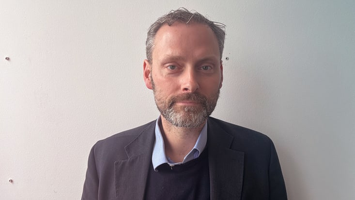Portrait von Jan Albroscheit vor einer weißen Wand