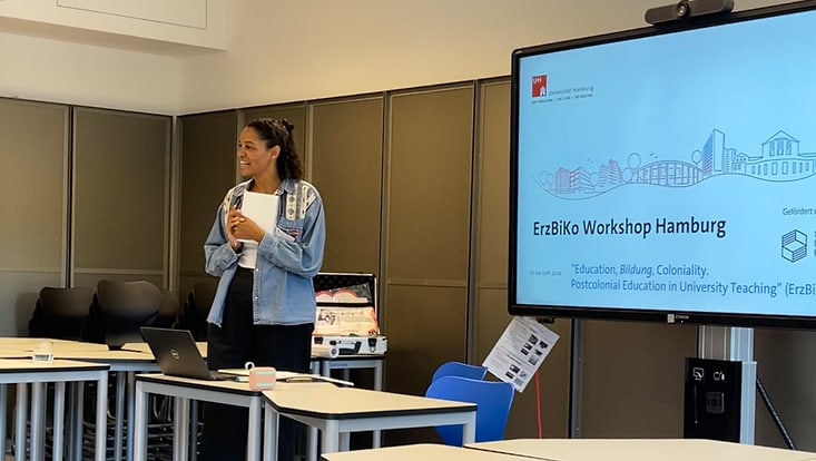 erzbiko-4-733x414 Eine Person steht vor einem eingeschalteten Smartboard und und spricht zu einem nicht im Bild erkennbaren Publikum. Auf dem Smartboard ist der Titel der Veranstaltung zu erkennen: ErzBiKo-Workshop Hamburg.
