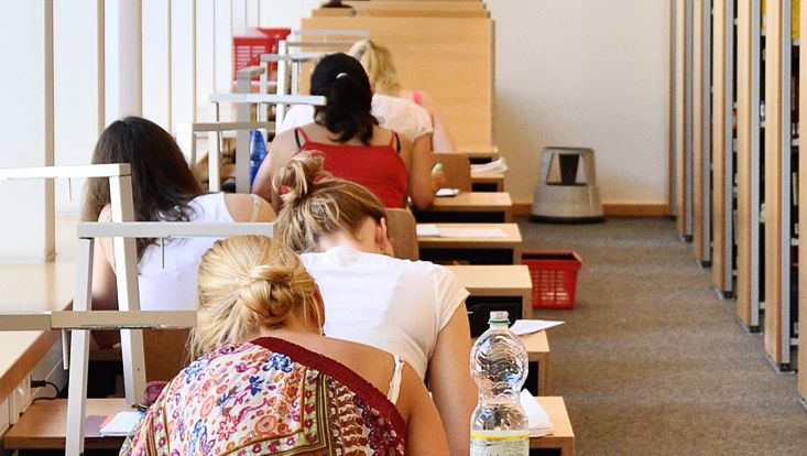 Studierende an Arbeitsplätze von hinten fotografiert
