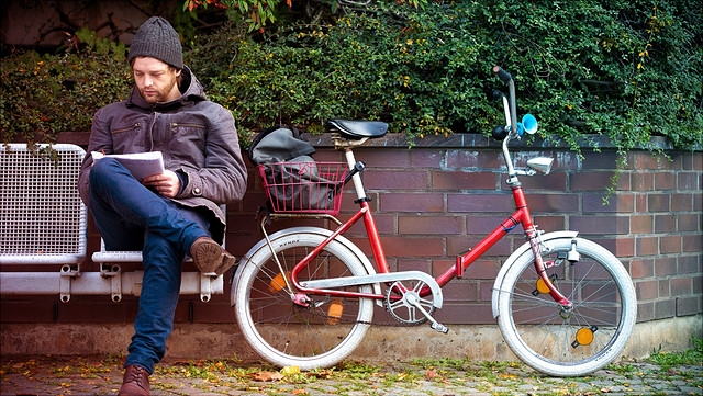 Student auf Bank mit Fahrrad