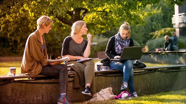 Studierende auf einer Bank im Freien
