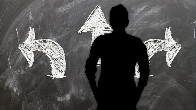 Männlicher Schatten vor einer Tafel mit drei Pfeilen