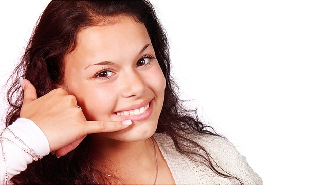 Frau, die Hand wie einen Telefonhörer hält