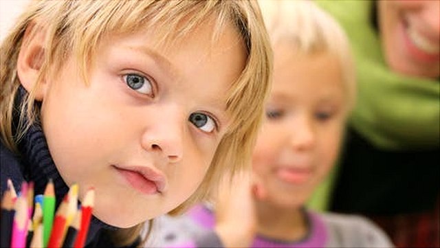 Junge im Vordergrund sieht in die Kamera