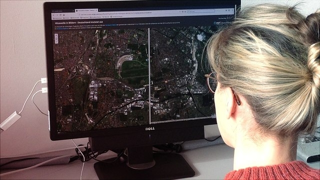 Frau arbeitet mit Geographie-Programm an Computer.