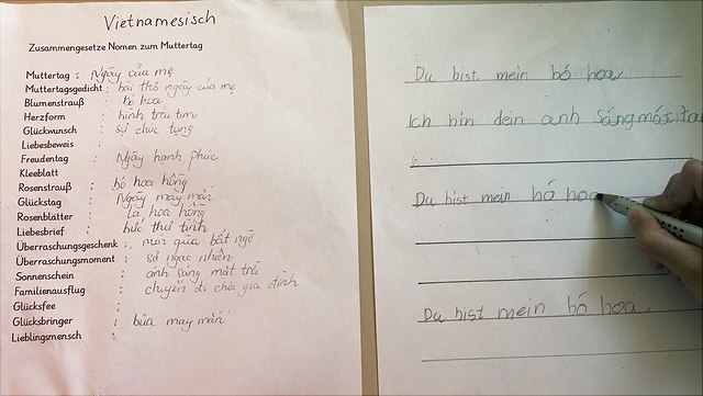Ein Gedicht in Deutsch und Vietnamesisch wird geschrieben.