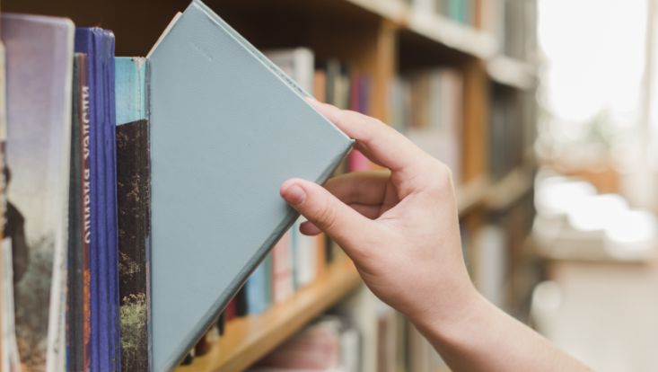Hand nimmt Buch aus Regal