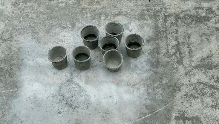 Darstellung der Ziffer 7 durch 7 Eimern, die auf Betonboden stehen