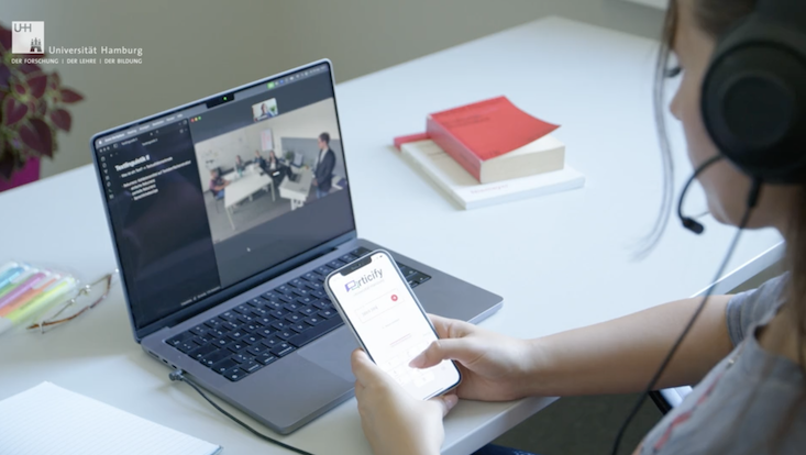 hands-on-workshops-foto-733-414 Eine Person vor einem Laptop nimmt an einer Umfrage am Smartphone teil