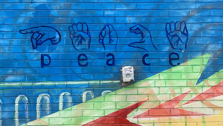 Peace in Gebärdensprache auf Wand gesprayt