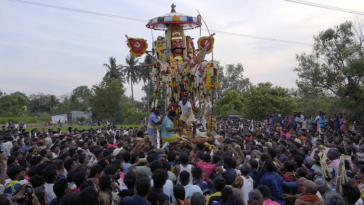 crowd and festive scene centering a statue