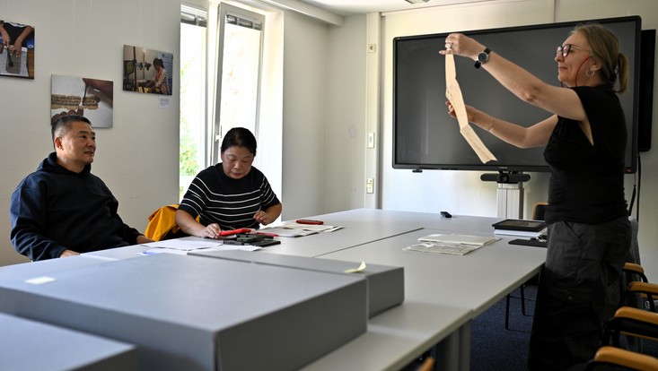 Agnieszka Helman-Wazny (right) studying a Chinese paper sample brought to the CSMC by Guang Jin (left) and Lingyan Qiu (middle).