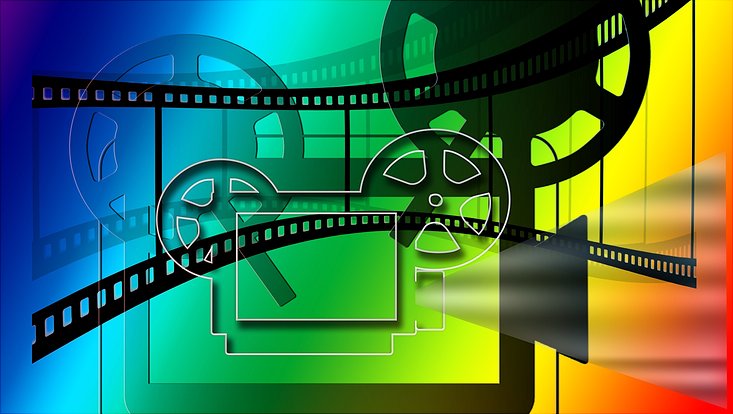 Ein Filmprojektor als Grafik auf regenbogenfarbenem Hintergrund