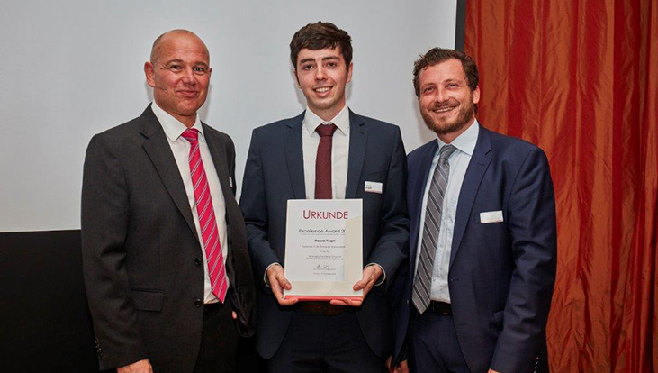 Prof. Markus Warg vom VFVH überreicht den Excellence Award an Preisträger Pascal und Betreuer Dr. Martin Semmann