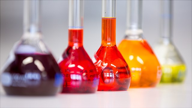 5 Messkolben gefüllt mit verschieden farbigen Flüssigkeiten
