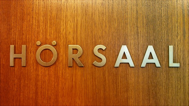 Juniorstudium Schriftzug Hörsaal Messing auf Holz