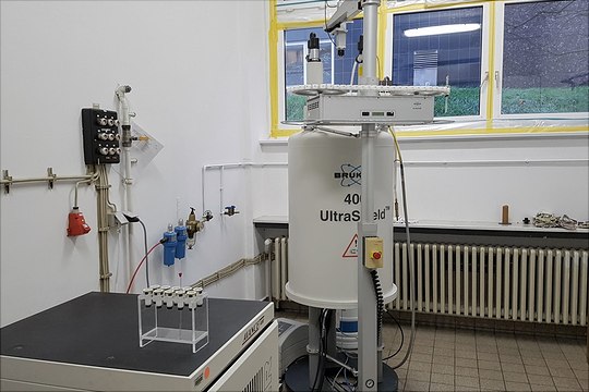 av4002-540x360 400 MHz NMR-Magnet mit Konsole und Probenständer in einem Raum vor weißer Wand mit Fensternim Hintergrund