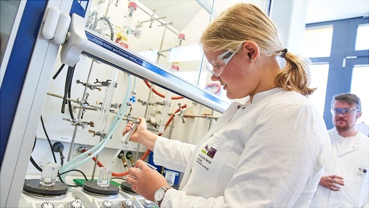 Schülerin bei der Synthese von Gold-Nanopartikeln: Zu einer Goldsäurelösung wird vorsichtig eine Trinatriumcitratlösung hinzugetropft.