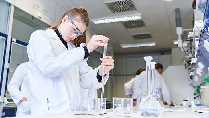 Eine Schülerin beim Abmessen der Lösungen für den Versuch „Der chemische Sonnenuntergang“.